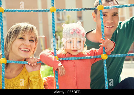 child with parents at the playground Stock Photo