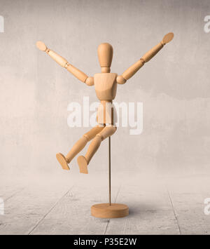 Wooden mannequin posed in front of a greyish background Stock Photo