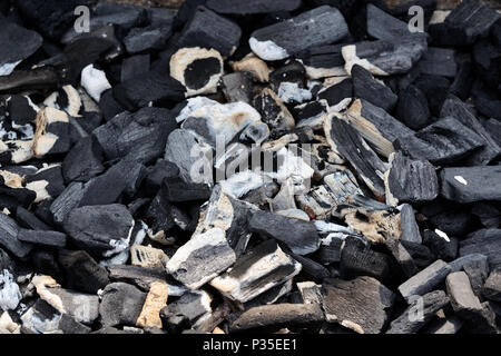 Top view of hot charcoal glowing in a grill pit. Abstract charcoal background, texture or wallpaper. Burning coals for cooking food on grill. Stock Photo