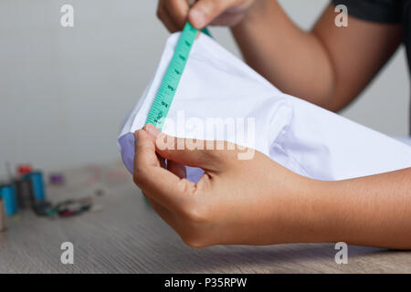 Close up a women are measuring the size of the sleeve. Select focus shallow depth of field and blurred background. Stock Photo