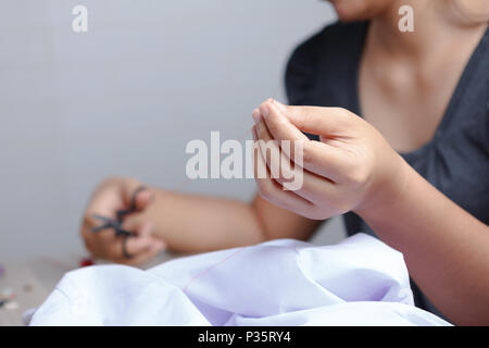 Close up hand of woman is using sewing scissors. Select focus shallow depth of field and blurred background. Stock Photo