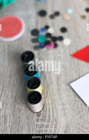 Close up the thread that was placed on the wooden table to sew with high angle view. Select focus shallow depth of field and blurred background with c Stock Photo