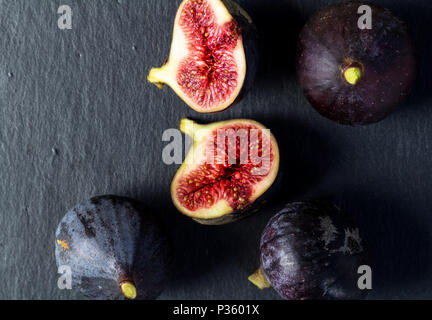 Figs whole and sliced close up top view on black Stock Photo