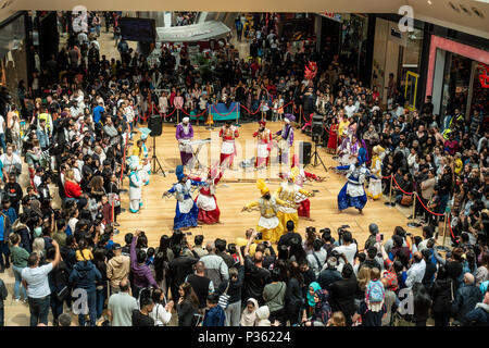 The Lions of Punjab, a Bhangra dancing troupe, perform an energetic routine to an appreciative audience in Birmingham's Bullring Shopping Centre. Stock Photo