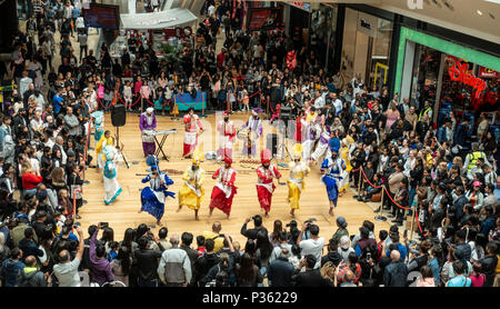 The Lions of Punjab, a Bhangra dancing troupe, perform an energetic routine to an appreciative audience in Birmingham's Bullring Shopping Centre. Stock Photo