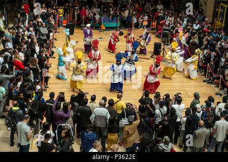 The Lions of Punjab, a Bhangra dancing troupe, perform an energetic routine to an appreciative audience in Birmingham's Bullring Shopping Centre. Stock Photo