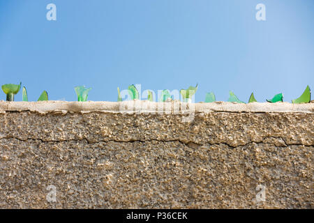 Glass shards on top of a wall for protection, Spain. Stock Photo