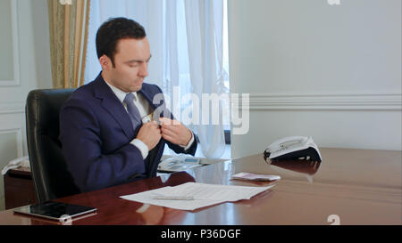 Dishonest businessman in suit looks back, counts money and takes some euro banknote Stock Photo