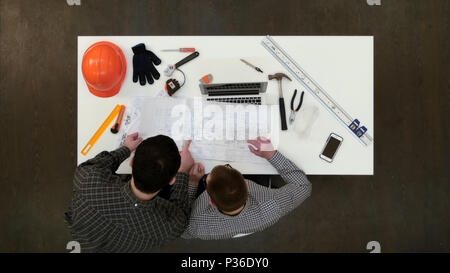 Two male architects discussing drawings and blueprints Stock Photo