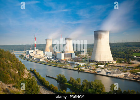 Daytime long exposure shot of a nuclear power plant at a river with blue sky and some clouds as well as blurred reflection. Stock Photo