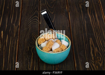 Shugar in the bowl over wooden background Stock Photo