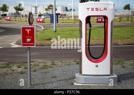 A Tesla Supercharger charging station at the Eurotunnel car park in Calais, France. The station is used to recharge electic vehicles. Stock Photo