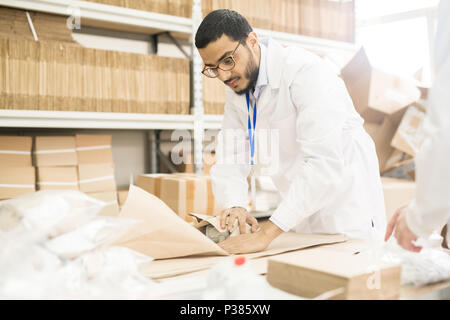 Factory Worker Wrapping Manometer in Paper Stock Photo