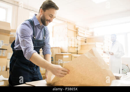 Smiling Warehouse Worker Packaging Equipment Stock Photo