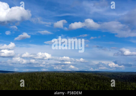 heavenly landscape - a blue sky with clouds over a wooded hilly land with a bird's eye view Stock Photo