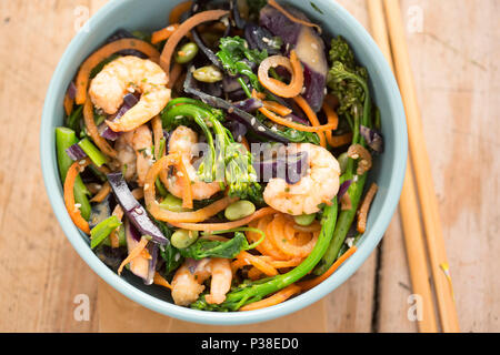 Stir fry with carrots, red cabbage, broccoli, kale, edamame, spring onions, seeds & prawns Stock Photo