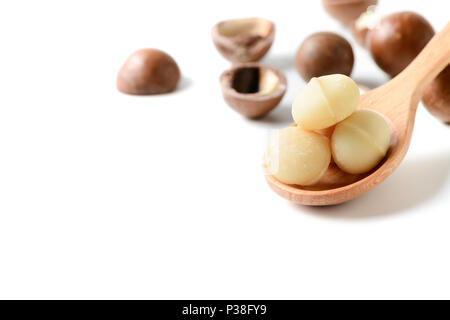 macadamia nuts on wood spoon isolated on white background with copy space Stock Photo