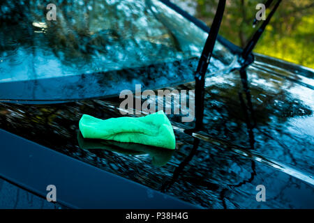 green sponge over the car for washing. Car washing outdoor. Cleaning concept.Transportation self service, care concept. Car service. Stock Photo