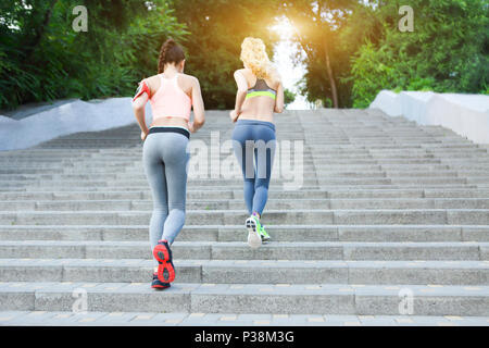 Runners training outdoors working out in the park with sunset light Stock Photo
