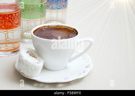 Turkish coffee with milk cream chocolate pistachio Turkish delight and cup of water background Stock Photo