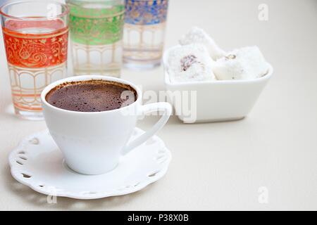 Turkish coffee with milk cream chocolate pistachio Turkish delight and cup of water isolate Stock Photo