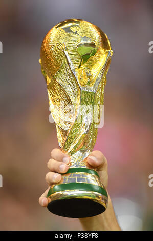 A Fan Holds Up A Replica Of The FIFA World Cup Trophy While Waiting For a-fan-holds-up-a-replica-of-the-fifa-world-cup-trophy-while-waiting-for