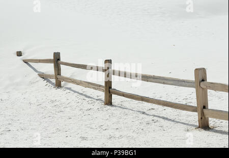 Wood fence buried by a sand dune in southern New Mexico Stock Photo