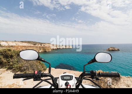 ATV quad bike parked on the shore of Aegean sea on Milos island, Greece. View from driver seat Stock Photo