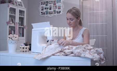 Young beautiful woman using electric sewing machine Stock Photo