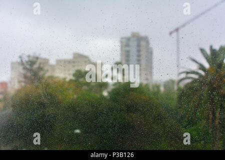 Rain droplets running down a window glass on a rainy day in Maldonado, Uruguay Stock Photo