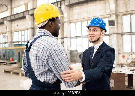 Cheerful businessman collaborating with construction manager Stock Photo
