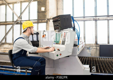 Factory operator working on control panel of manufacturing machi Stock Photo