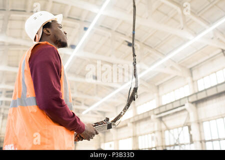 Construction worker using crane controller Stock Photo