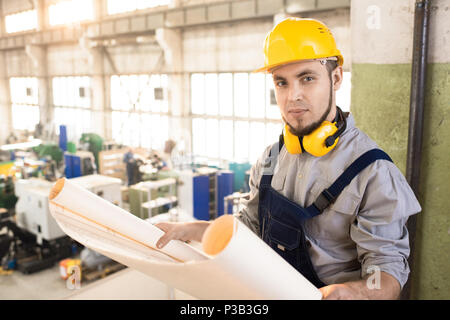 Confident engineer analyzing blueprint Stock Photo