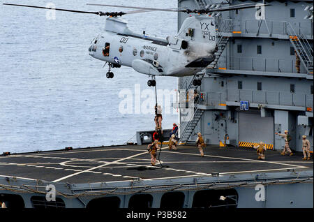 PACIFIC OCEAN - Marines assigned to the Ground Combat Element of the 11th Marine Expeditionary Unit, embarked amphibious dock landing ship USS Rushmore (LSD 47), fast rope out of a CH-46E Sea Knight on to the deck of the Military Sealift Command fleet replenishment oiler USNS Yukon (T-AO 202) during a visit, board, search and seizure exercise. Rushmore is part of the Bonhomme Richard Amphibious Ready Group and is underway conducting a Composite Training Unit Exercise (COMPTUEX) in preparation for a scheduled deployment to the western Pacific Ocean later this year. Stock Photo