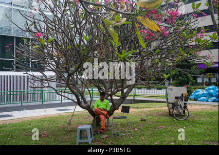 Singapore, Republic of Singapore, guest worker takes a break on a tree Stock Photo