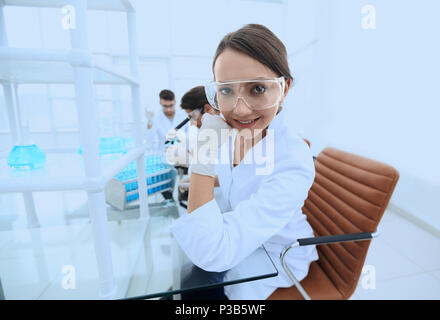 Investigator checking test tubes, Woman wears protective goggles Stock Photo