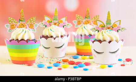 Adelaide, South Adelaide - June 15, 2018: Children's birthday party unicorn and rainbow themed cupcakes, close up against a colorful pastel background Stock Photo