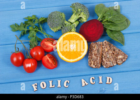 Inscription folic acid with nutritious products containing vitamin B9 and natural sources of minerals, concept of healthy nutrition Stock Photo