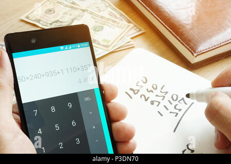 Man using smartphone for calculation of home budget. Counting money. Stock Photo