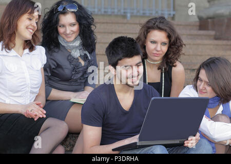 group of students communicating via the Internet using laptop Stock Photo