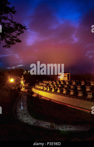 108 memorial chortens of Dochula shining in its glory at dusk with heavy clouds giving company to the blue sky Stock Photo