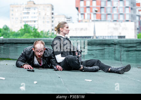 Actors rest from shooting a scene with weapons Stock Photo