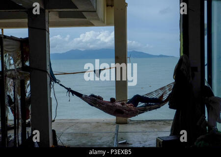 Afternoon nap in a hammock. During the building of a new hotel, construction workers  are taking a break. Photographed in fisherman village district,  Stock Photo