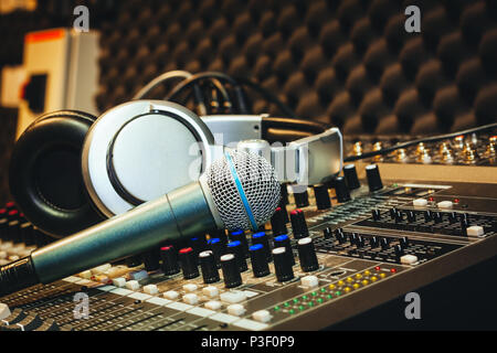 Close up instruments music background concept.Single microphone with headphones on sound mixer board in home recording studio.Free space for creative  Stock Photo
