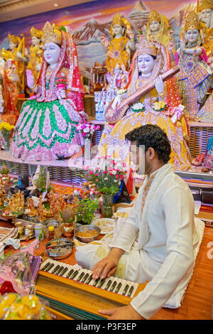 A pundit playing the harmonium & leading services at the Tulsi Mandir temple in South Richmond Hill, Queens, New York. Stock Photo