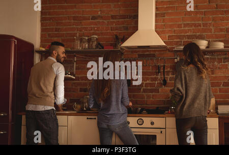 Friends preparing food in kitchen Stock Photo