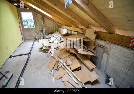 Rebuilding, renovating or remodelling house attic and constriction waste. Tearing down old and building new room or mansard in house attic under the r Stock Photo