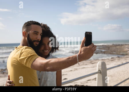 Couple taking selfie with mobile phone near beach Stock Photo