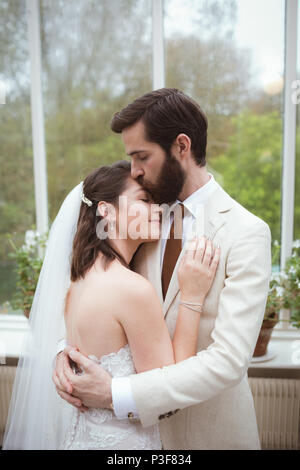 Bride and groom embracing each other Stock Photo